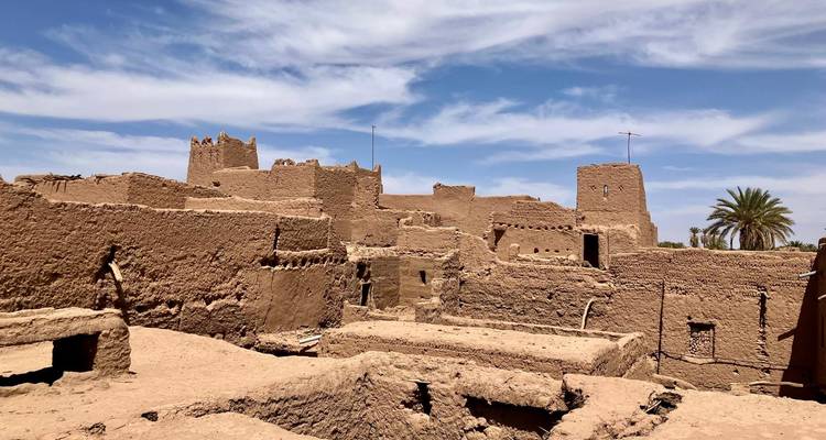 Lehmziegelgebäude unter einem teilweise bewölkten Himmel.