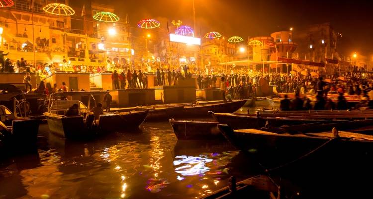 Nachtansicht eines überfüllten Ghats in Varanasi mit Lichtern.