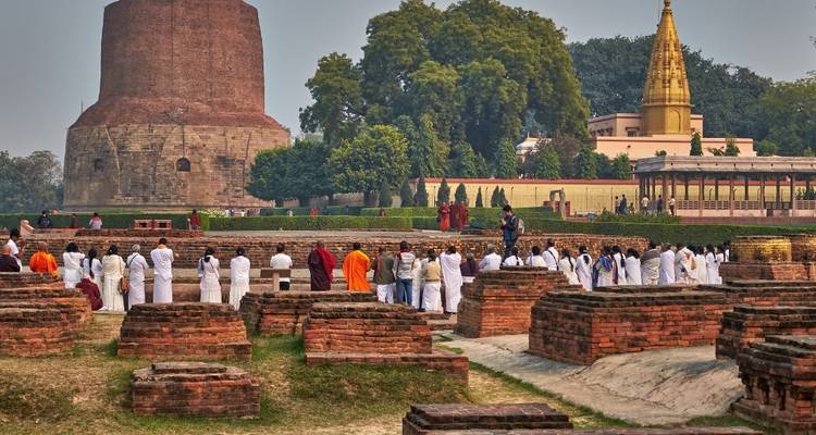 Mönche versammelten sich an einer historischen Stätte mit großen Stupas.