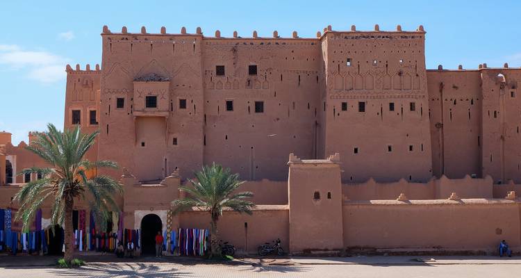 Kasbah Taourirt, ein historisches Bauwerk mit Palmen und Mauern.