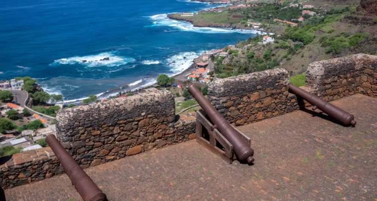 Ancienne forteresse de pierre avec des canons rouillés surplombe une côte atlantique rocheuse.