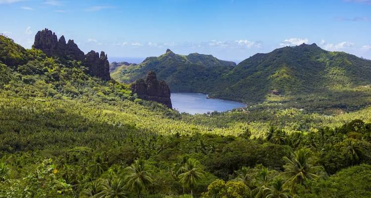 Üppig grüne Berge umgeben eine abgeschiedene Bucht, betrachtet von einem Panorama-Aussichtspunkt auf den Marquesas.