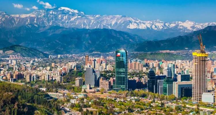 Large South American metropolis framed by the snow-dusted Andes under a clear blue sky.