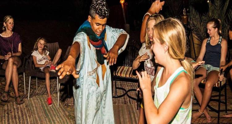 People enjoying a cultural dance activity in an outdoor setting at night.