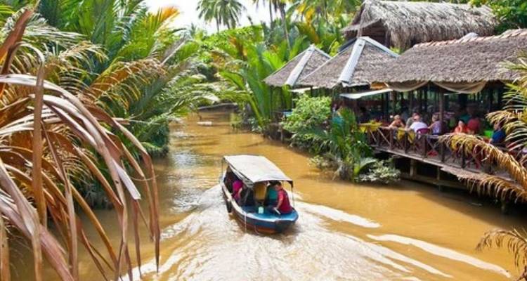 Boot met toeristen op een kanaal omringd door palmbomen