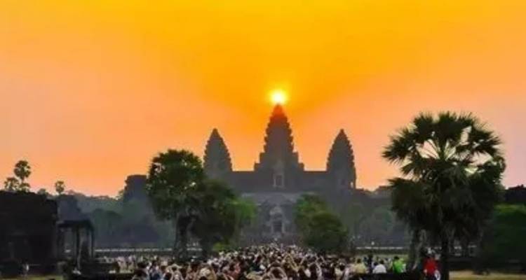 Menigte die zonsopgang achter een tempel bekijkt