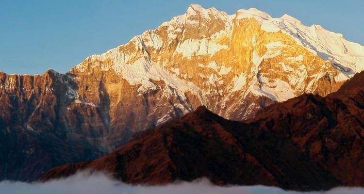 Sommet de montagne enneigé pendant l'heure dorée.