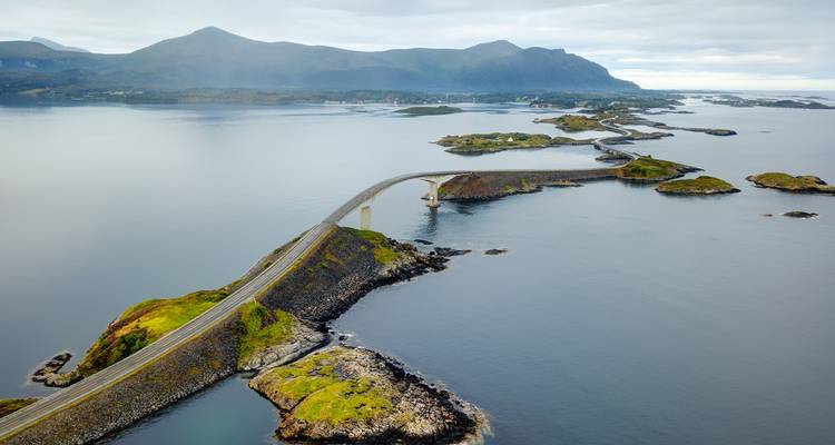Vista aérea panorámica de la serpenteante Carretera del Océano Atlántico que conecta pequeñas islas verdes.