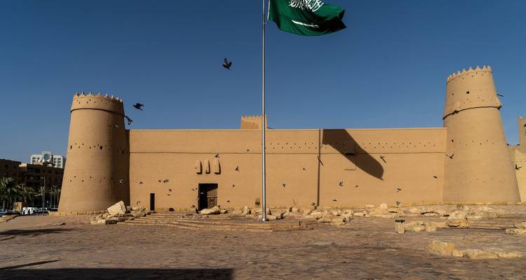 Historische Lehmziegelfestung mit saudischer Flagge im Wind.