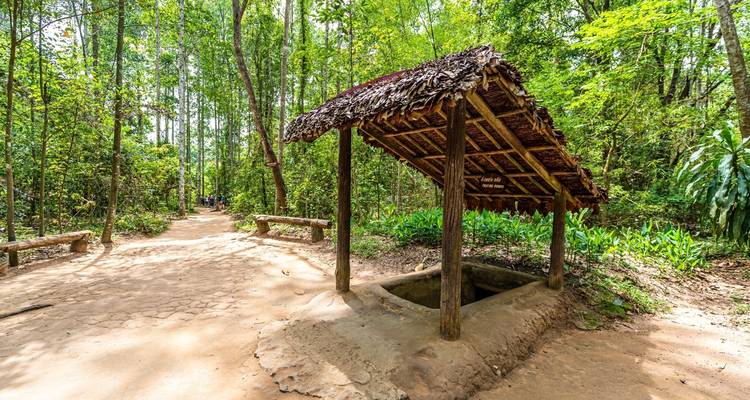 Estructuras de madera con techos de paja sobre una entrada subterránea.