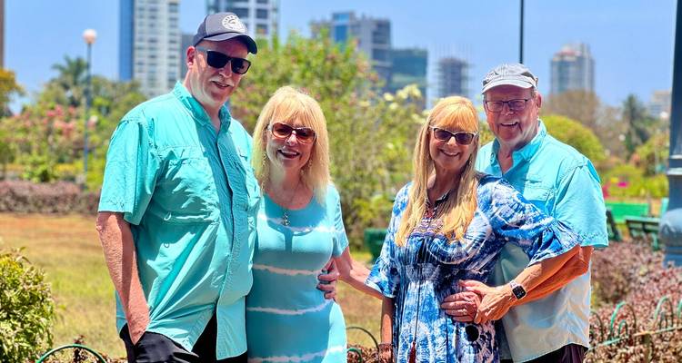 Group of four people posing in an urban park.