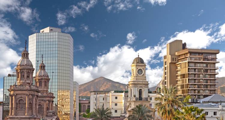 Architectuur die moderne en historische gebouwen vermengt met de Andes op de achtergrond.