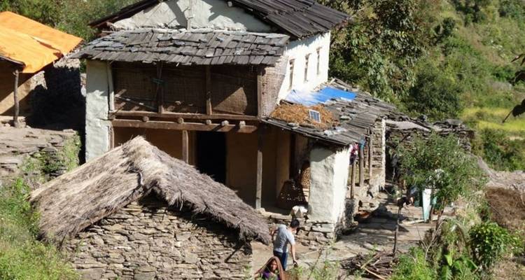 Maisons traditionnelles en pierre avec des toits de chaume dans un village de montagne.