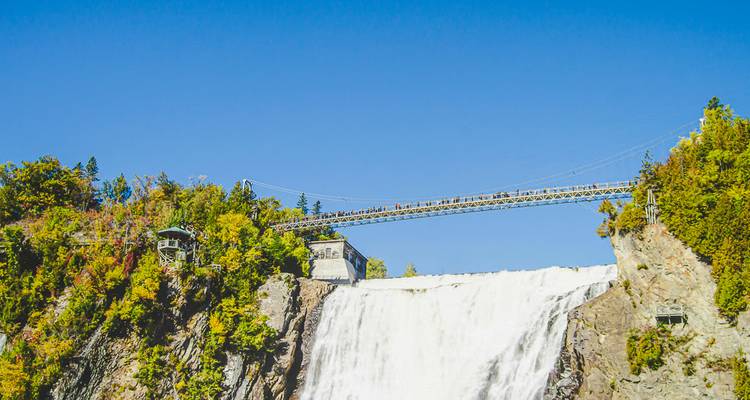 Les chutes Montmorency plongeant sous une passerelle suspendue par une journée claire.