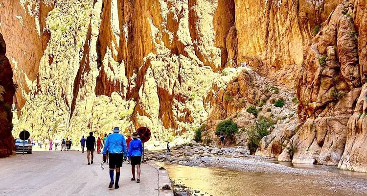 Des gens marchant à travers une gorge étroite aux parois rocheuses imposantes.