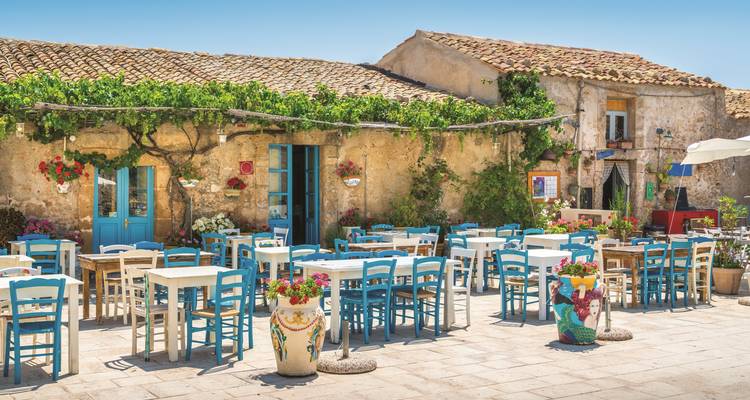 Café al aire libre con arquitectura mediterránea y decoración colorida