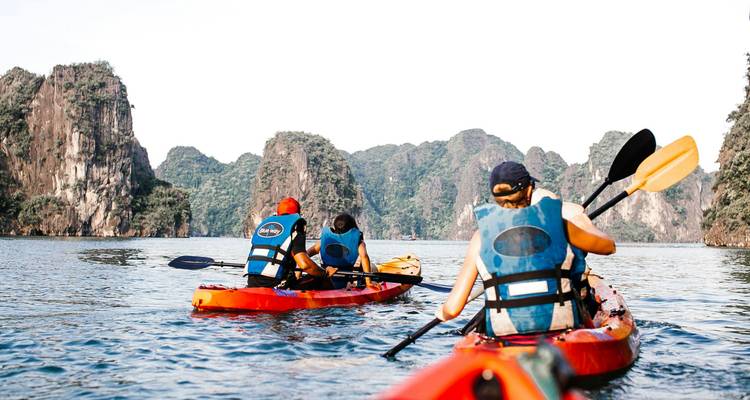 "Faire du kayak dans la baie d'Halong entourée d'îles calcaires."