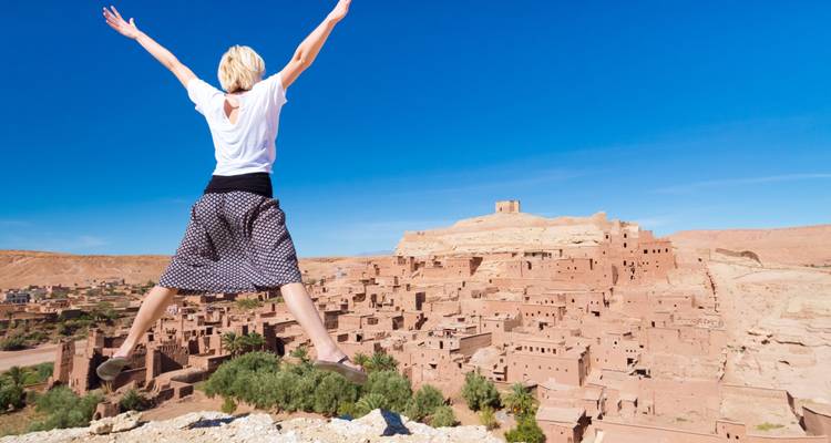 Personne sautant les bras étendus surplombant un village.