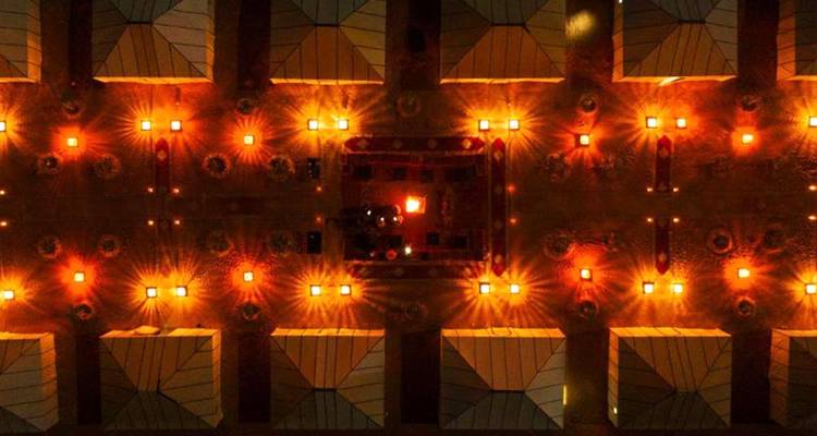 Luftaufnahme eines Wüstenlagers bei Nacht, beleuchtet von Lichtern.