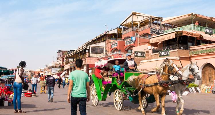 Una vibrante escena callejera en una ciudad con carruajes tirados por caballos y puestos de mercado.