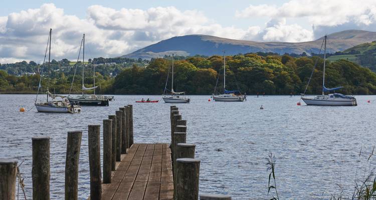 Boats moored on a lake with hills in the background.