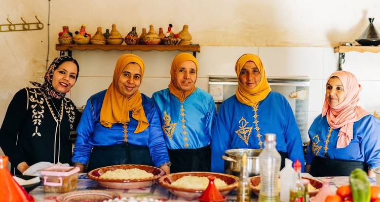 Vrouwen in traditionele kleding die eten bereiden.