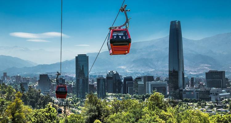 Cable cars over a city with skyscrapers in the background.