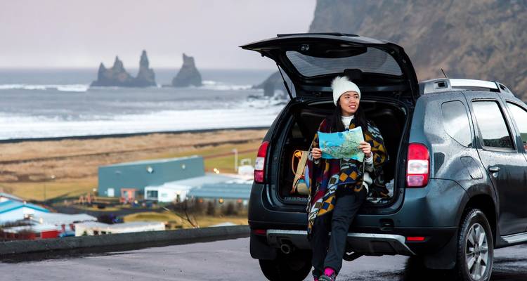 Persona con un mapa sentada en la parte trasera de un coche.