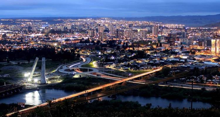 Paysage urbain au crépuscule avec des lumières illuminant une grande zone urbaine.