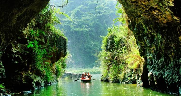 Boat with people navigating through a stunning river canyon.
