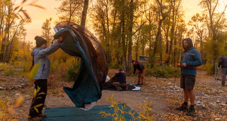 Grupo instalando campamento en un bosque.