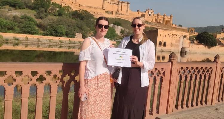 Twee vrouwen die een welkomstbord vasthouden voor een fort.