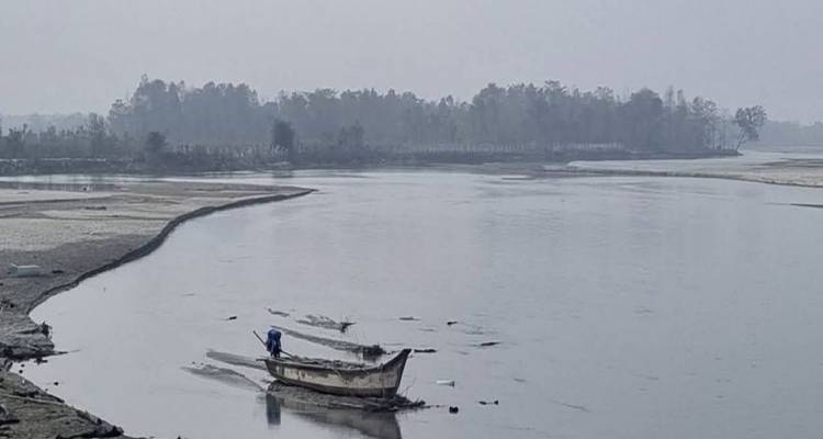 Un bateau sur une rivière calme avec un rivage boisé au loin.