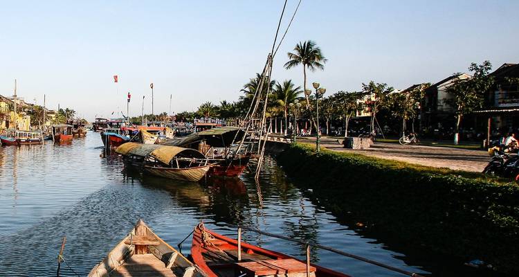 Flussuferblick mit Booten und Palmen in Hoi An, Vietnam