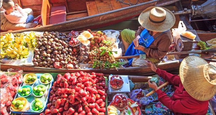 Floating market with vendors selling fruits from boats.