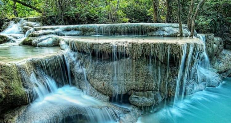 Beautiful tiered waterfall in a lush green forest.