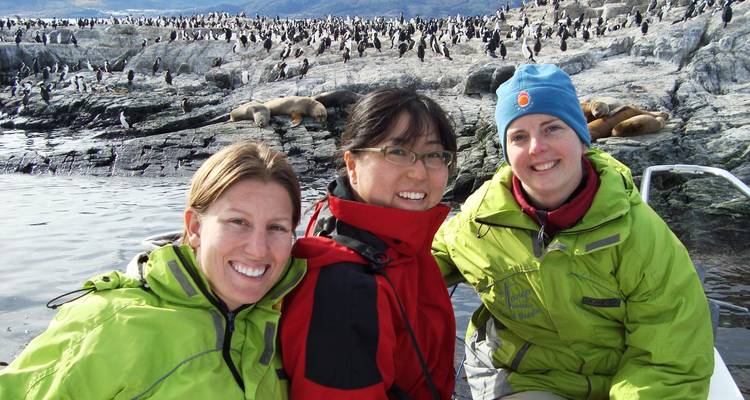 Group of people in front of penguin colony.