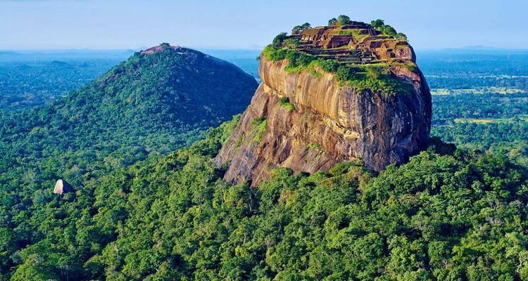 La icónica fortaleza rocosa de Sigiriya elevándose sobre la interminable jungla de Sri Lanka bajo la luz cristalina de la mañana.