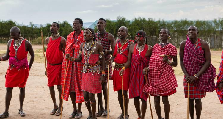 Eine Gruppe von Maasai-Männern in traditioneller Kleidung, die einen zeremoniellen Tanz aufführen.
