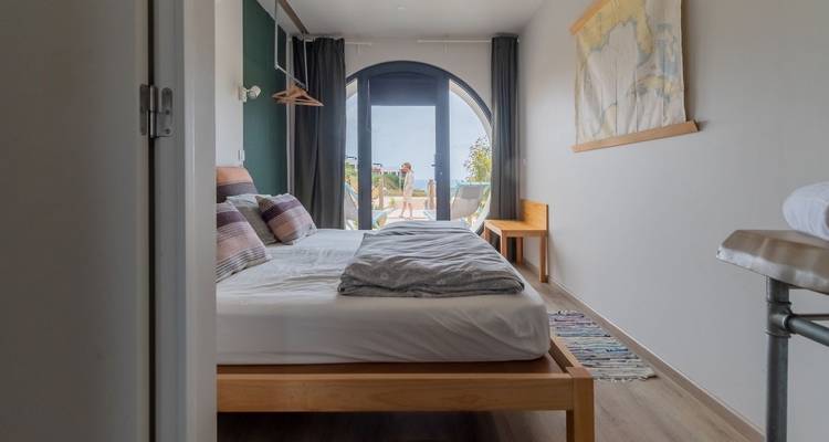 Interieurzicht van een gezellige en goed verlichte slaapkamer met een balkon.