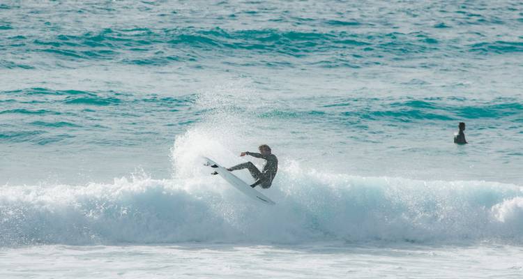 Een surfer die hartstochtelijk op een golf rijdt in de oceaan.