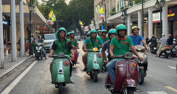 Eine Gruppe von Menschen, die mit Rollern eine Stadtstraße hinunterfahren.