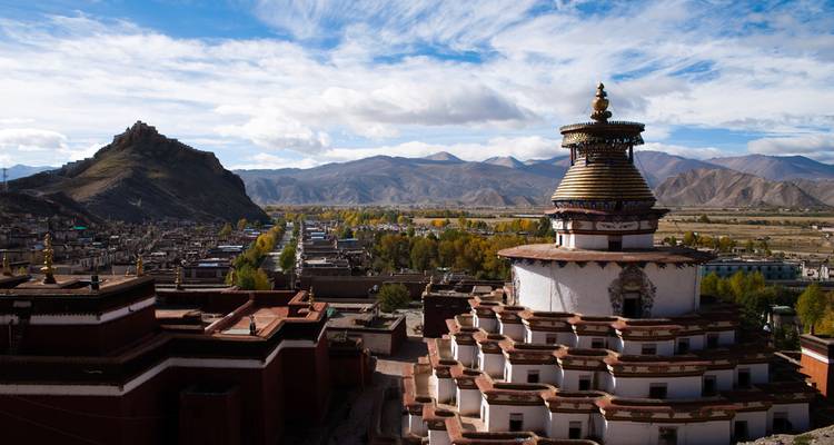 De imposante Gyantse Kumbum stupa beheerst een dalstad met op de achtergrond robuuste bergen.