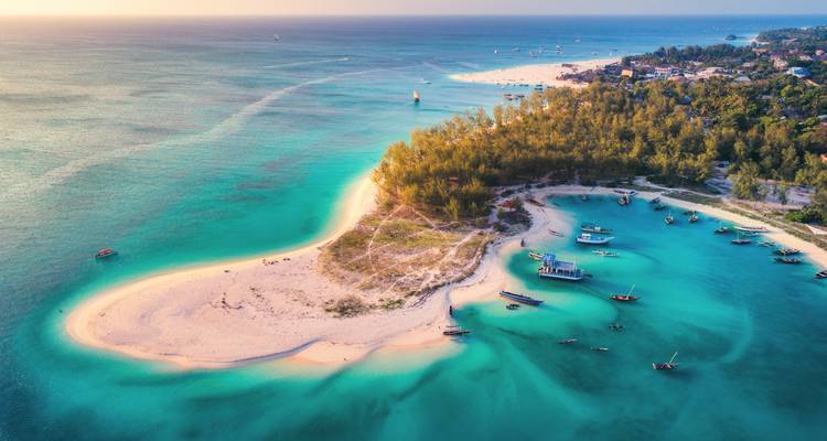 Aerial view of a turquoise bay with sandy beaches and a lush green island.