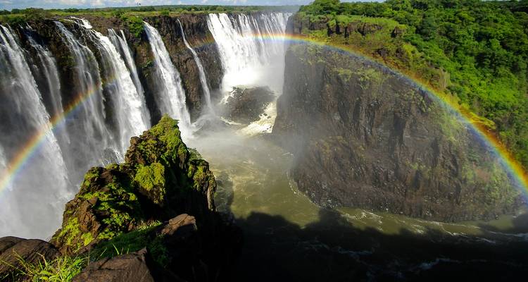 Spectacular waterfall with a rainbow arching across the misty falls.