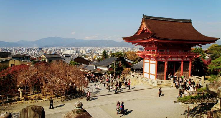 Las multitudes se reúnen cerca de la puerta de la pagoda roja que domina la vista panorámica de la ciudad de Kioto y las montañas que la rodean.