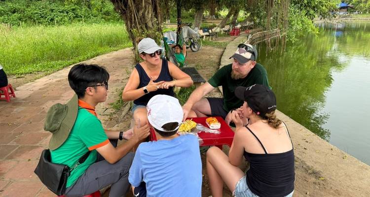 Des gens assis autour d'une table en train de parler en plein air à Hanoï.