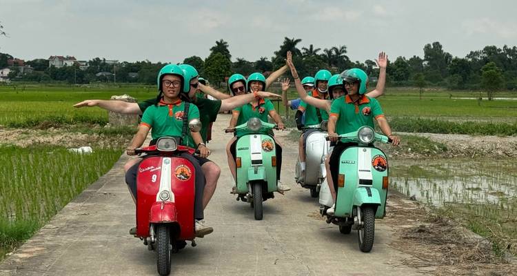 Groupe de conducteurs de scooter posant et saluant de la main dans une zone rurale.