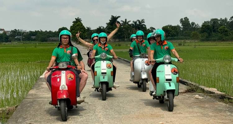 Groupe de personnes profitant d'une excursion en scooter dans une région rurale pittoresque.