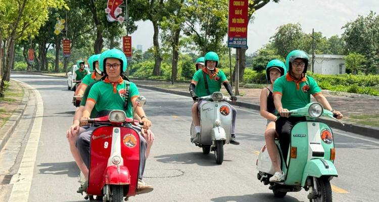 Des personnes en scooter roulant sur une route bordée d'arbres.